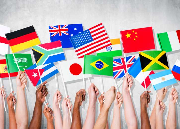 Group of hands holding national flags. Cómo Manejar los Contratos de Alquiler con Inquilinos Internacionales